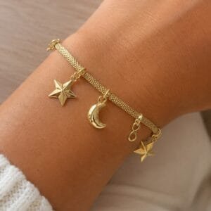 Pulsera dorada con dijes estrella, luna e infinito
