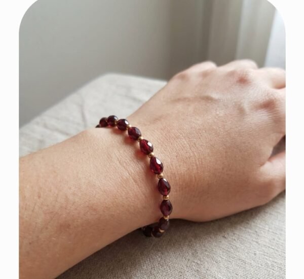 Pulsera en elástico gota facetada bordo con balines dorados