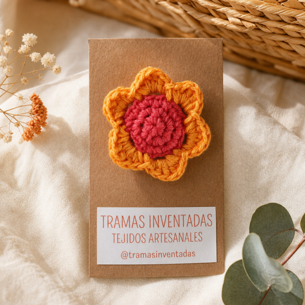 Prendedor con flor tejida a mano en anaranjado y coral